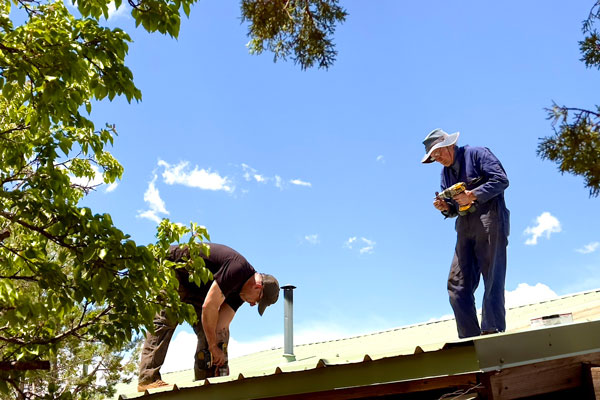 Two men working on a roof.